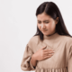 Chica con su mano apoyada en el pecho por un dolor en el pecho